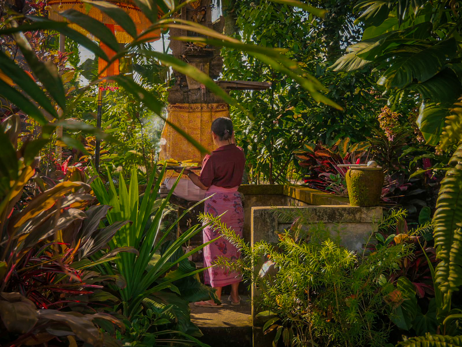 donna balinese mentre prega in un tempio a bali immerso nella natura