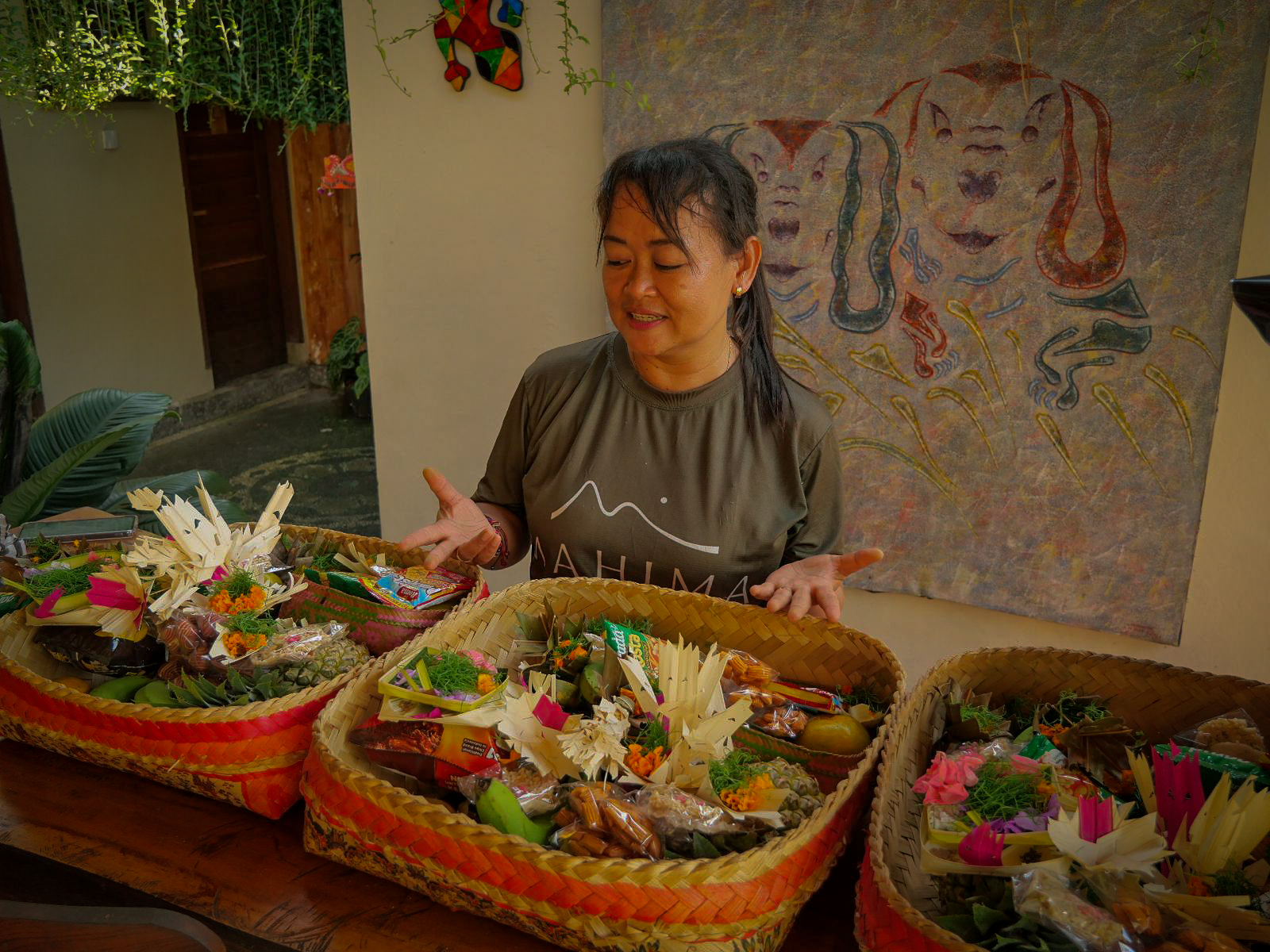 donna balinese mentre mostra dei banten, cestini con le offerte religiose